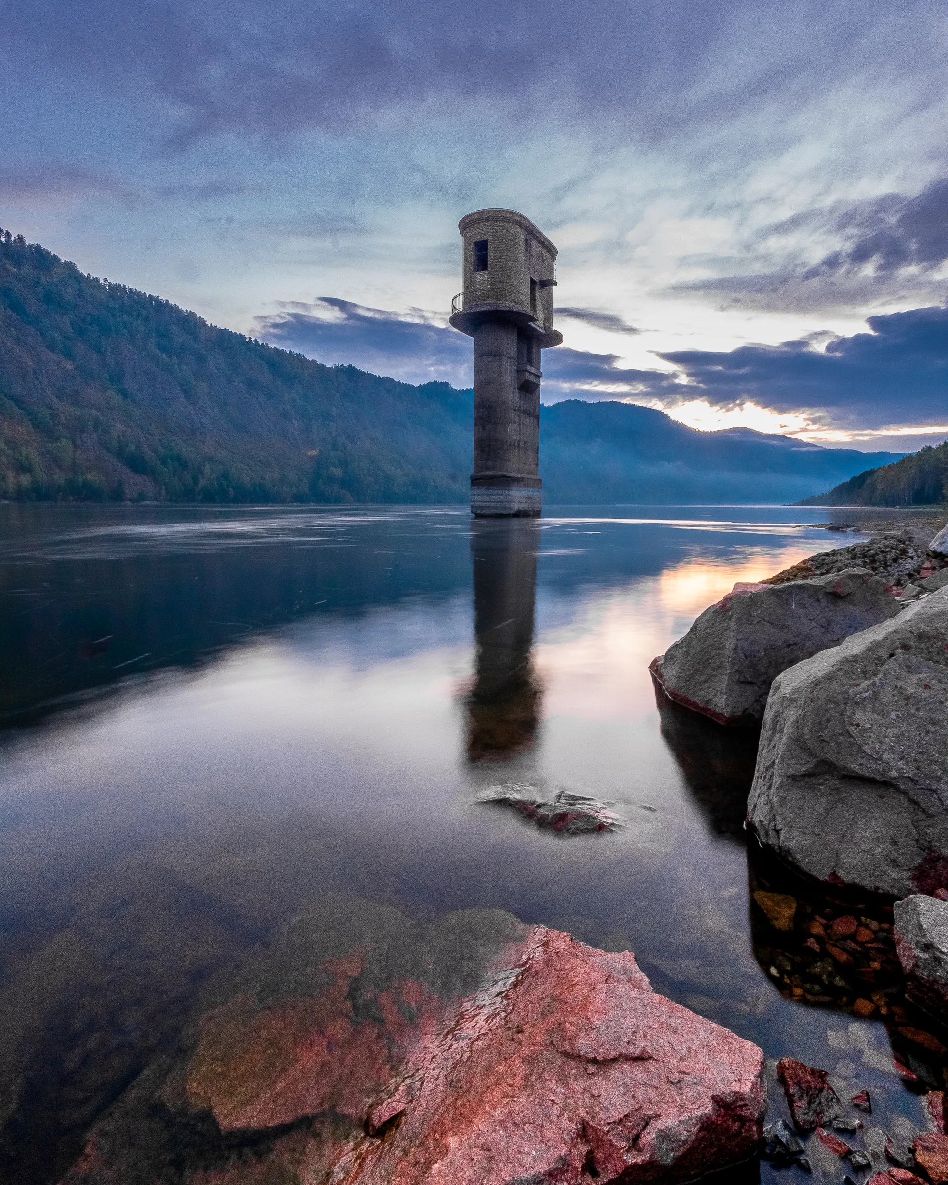 Still lake and tower in muted morning light