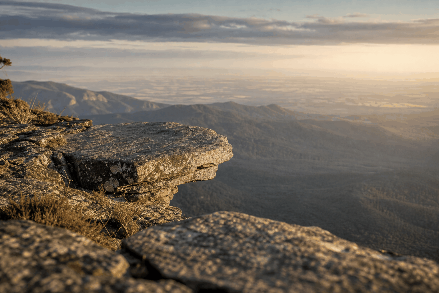 A natural stone ledge overlooking a valley, suggesting the right bench and strategic vantage point
